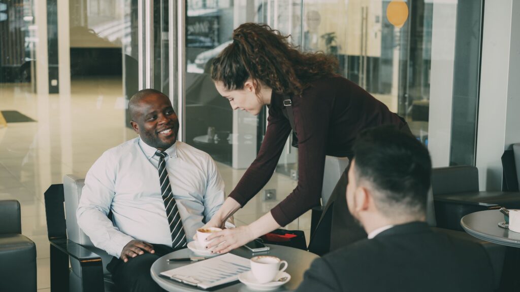Tax Services Business professionals enjoying coffee during a casual meeting at a café.