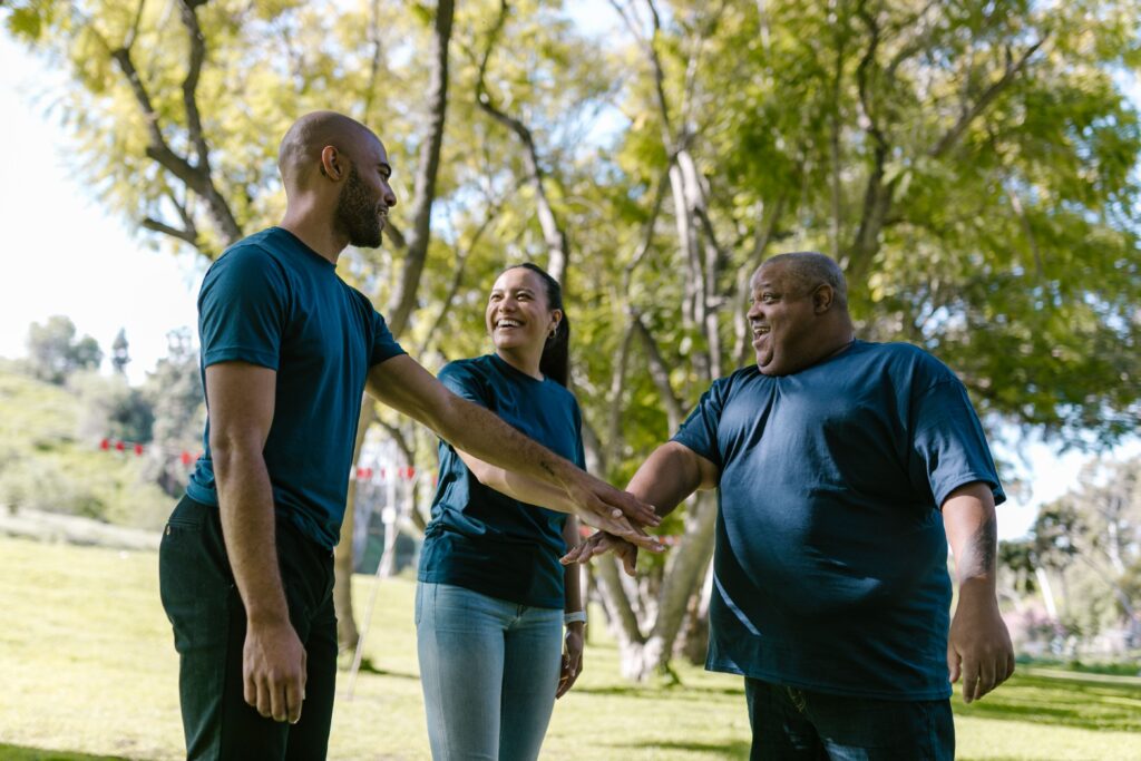 Accounting Services Group of diverse adults enjoying a team building exercise in a sunlit park.